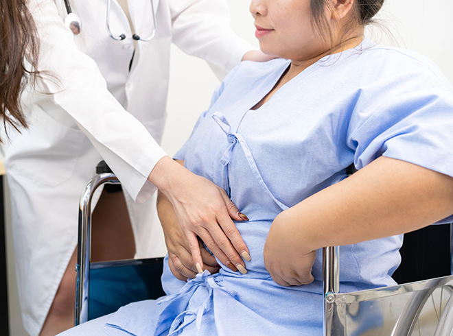 Healthcare provider supporting patient in wheelchair during wellness visit, illustrating lay navigator engagement, motivational interviewing, and social support planning for community-based care under G0019 and G0022.