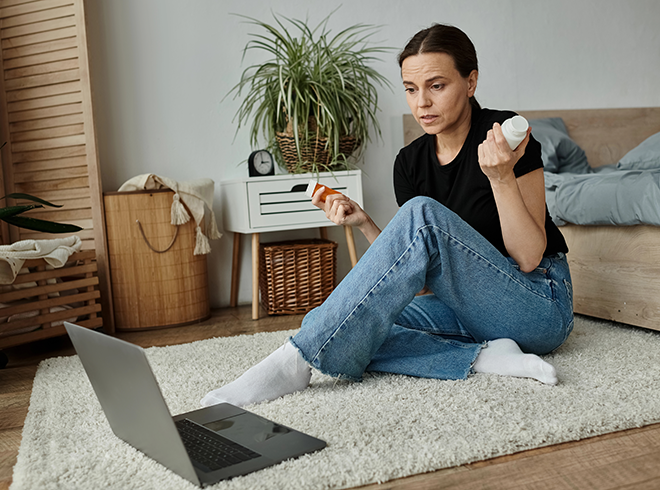 Woman holding two medication bottles during virtual consultation at home, illustrating telehealth medication review, patient engagement, and remote chronic care management