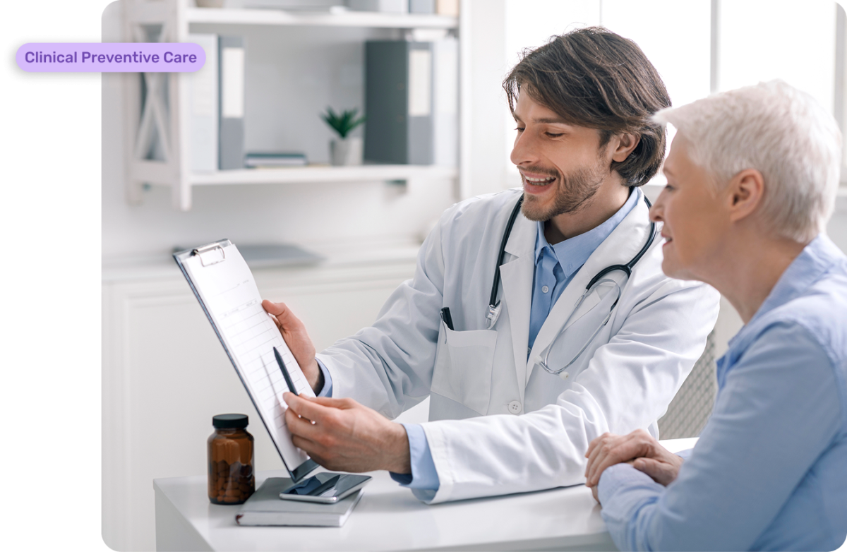 Smiling male doctor in a white coat with a stethoscope reviewing a clipboard with an older female patient, discussing a care plan as part of Chronic Care Management (CCM) services.