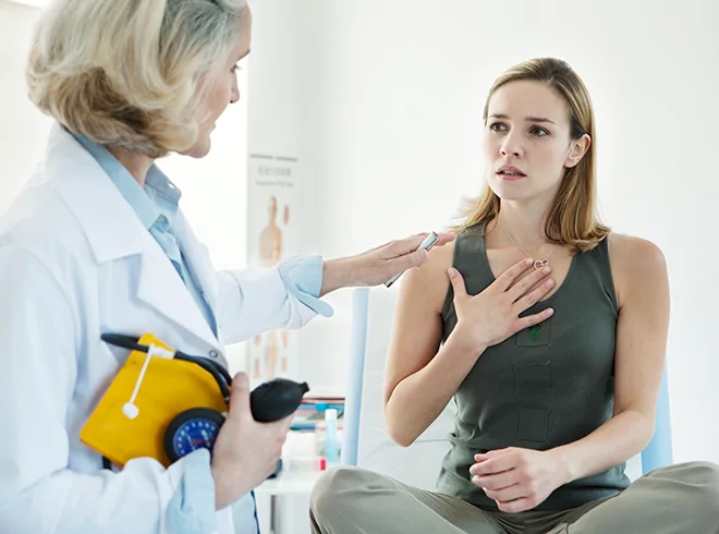Female patient describing chest pain to clinician during diagnostic evaluation, illustrating symptom assessment and early intervention in primary care