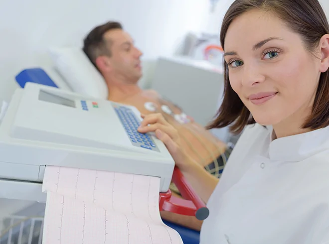 Healthcare technician performing ECG test on male patient, capturing cardiac monitoring and diagnostic support in cardiovascular care