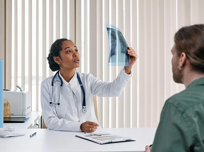 Doctor reviewing X-ray with patient during Chronic Care Management encounter